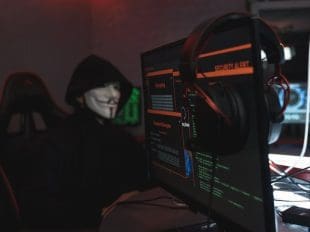 Person in Black Hoodie Hacking a Computer System